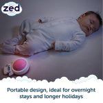 Baby asleep in white sleep suit showing Zed on mattress.